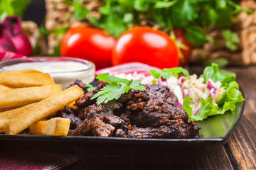 Kebab of beef with french fries and salad