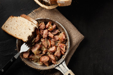 Pieces of sausage fried with onions