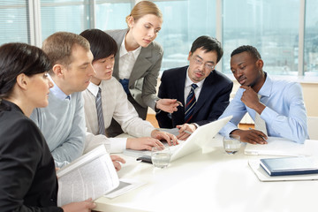 Group of business people working together on laptop in office
