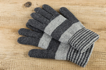 Fototapeta na wymiar Knitted gloves on wooden