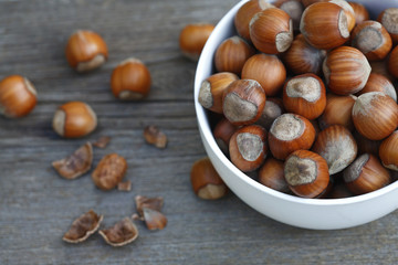 ripe hazelnuts in a bowl on a wooden table