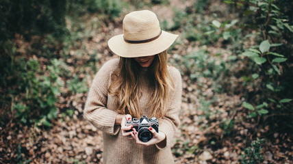 Stylish woman in hat with film camera