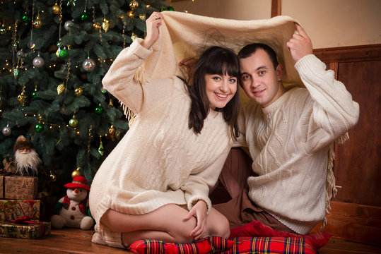 man and women with gifts near new year tree