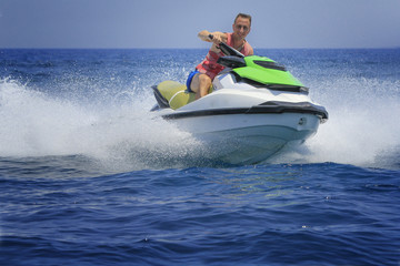 Fototapeta na wymiar Tourists enjoy driving jetski on the ocean