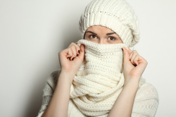 Beautiful natural young smiling brunette woman wearing knitted sweater, scarf and hat. Winter fashion concept.