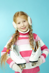 Portrait of little girl with skates and in warm clothing