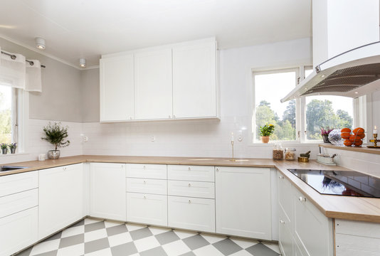 stilrent kök med rutigt golv och vita köksluckor