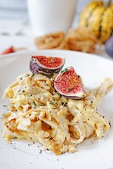 Creamy pasta with pumpkin and ricotta sauce, chopped walnuts and fresh figs.