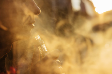 man using vape or electronic cigarette against the background of