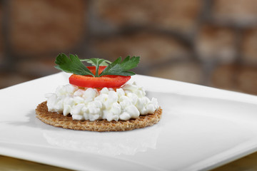 Sharply focused close up of fresh cottage cheese canape on blurred stone wall background. Image for a restaurant snack menu or party invitation cover design