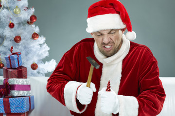 Wicked Santa breaking Christmas decorations with a hammer