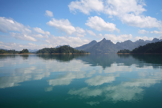 Beautiful scenery of the beautiful water reflection with clear sky at lake river in natural attractions,Ratchaprapha Dam at Khao Sok National Park,Surat Thani Province in Thailand.