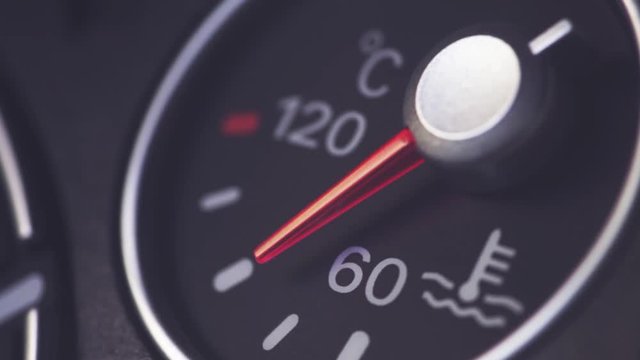 Color close up footage of a car's coolant temperature gauge with the indicator needle moving.