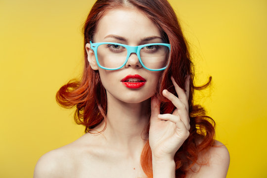 woman in glasses on a yellow background
