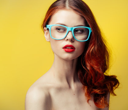 woman in glasses on a yellow background
