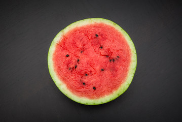 A half of fresh jucie red watermelon on black background.