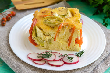 A piece of casserole of vegetables (zucchini, carrots) on a white plate. Vegetarian dish. Close up