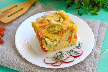 A piece of casserole of vegetables (zucchini, carrots) on a white plate. Vegetarian dish.