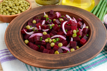 Vitamin salad of beets, green peas, blue onion in a clay bowl. Ingredients for cooking.