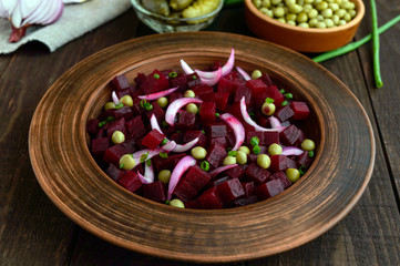 Vitamin salad of beets, green peas, blue onion in a clay bowl. Ingredients for cooking.