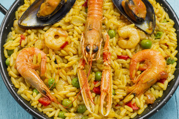 Spanish paella on a wooden table.