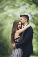 Fototapeta premium Young beautiful couple, girl with perfect dress posing in park