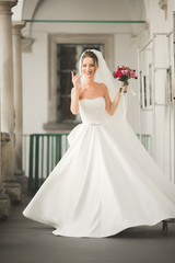 Wonderful bride with a luxurious white dress posing in the old town