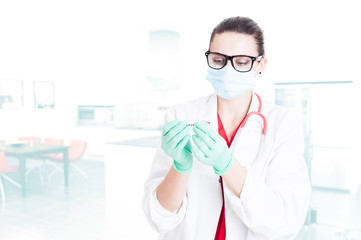 Young medical assistant preparing syringe for injection