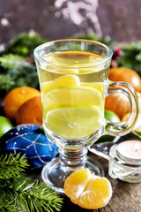 Close up hot tea and tangerine andchristmas ornaments.