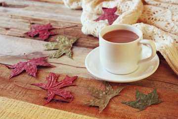 Obraz na płótnie Canvas Cup of hot chocolate, autumn leaves and knitted sweater