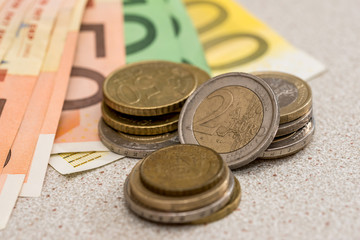 euro banknotes with coins on desk