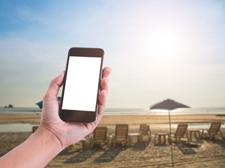 using smart phone showing blank white screen in woman hand on the beach. concept communication