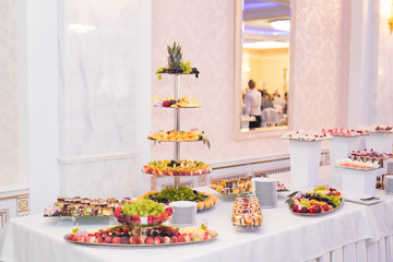 Delicious and tasty dessert table with cupcakes shots at reception closeup