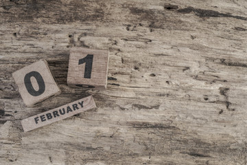 cube calendar for february on wooden background with copy space