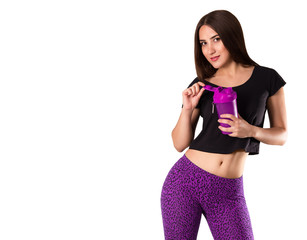 Sports young woman with a shaker in hand. Cool girl in fashion training tights. Tanned athletic girl in purple pants. Copy space. isolated on white background