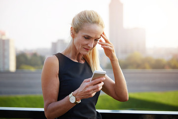 Upset businesswoman reading text message