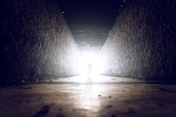 Mann geht ins Licht am Ende des tunnels