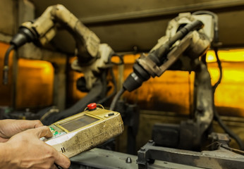 Team leader of production dept. Teaching new program to robot welding assembly automotive part in car factory,industrial estate Thailand
