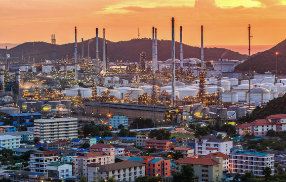 Oil Refinery factory in the sunset , petrochemical plant , Petroleum. and city around area