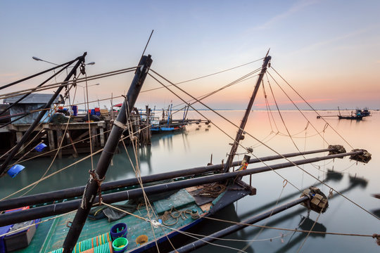 Fishing boats in harbour with sunset
