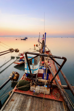 Fishing boats in harbour with sunset