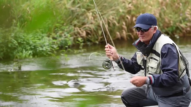 Fly-fisherman fishing in river