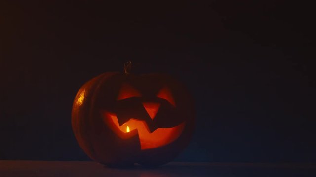 CU Halloween carved pumpkin Jack-o-Lantern with candles on dark background