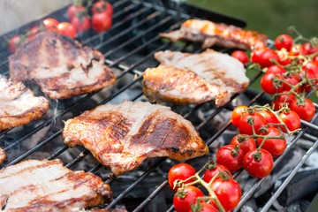 Delicious grilled meat with cherry tomatoes over the coals on a barbecue