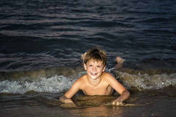 Children playing in the sea. The boy squirting water
