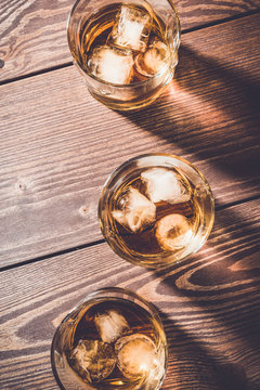 Glasses of whiskey on an old wooden table