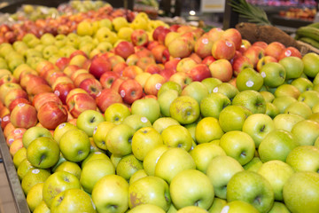 A market stall offering green and red apples.