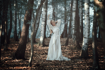 Beautiful woman dancing in ethereal forest