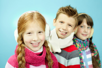 Portrait of three little children in warm clothing