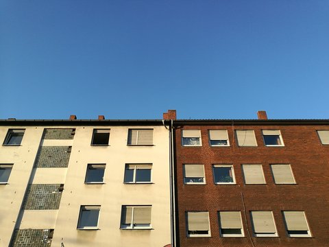 Fassaden alter Mietshäuser vor blauem Himmel im Licht der Abendsonne mit Rollladen als Sonnenschutz im Hafenviertel oder Hansaviertel in Münster in Westfalen im Münsterland